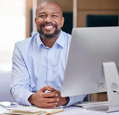 african american man smiling next to a computer